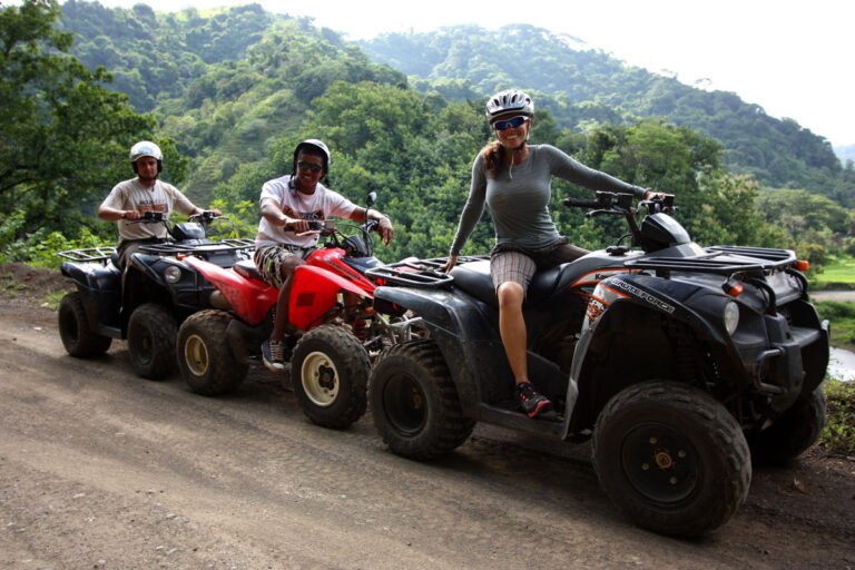 Riders on a dirt road with the green mountains behind them