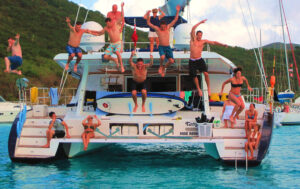 A group of tourists jumping off a party catamaran from Jacó to Tortuga Island in Costa Rica