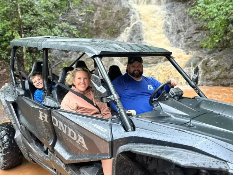 Couple in a UTV parked below a waterfall on the five-hour ride