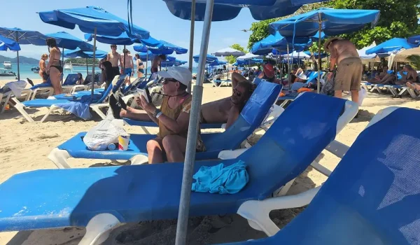 People enjoying the break-taking beach views of Tortuga Island from their beach chairs