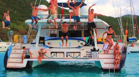 A group of tourists jumping off a party catamaran from Jacó to Tortuga Island in Costa Rica